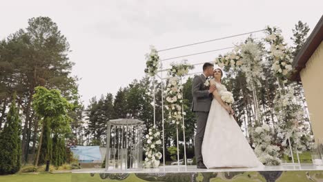 newlyweds, caucasian groom with bride walking, embracing, hugs in park, wedding couple