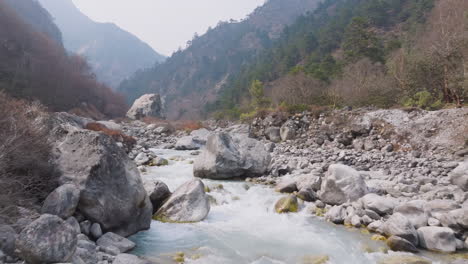 dudh koshi river flows from snowmelted himalayan region, nepal. wild forest, scenic trek path to everest base camp drone shot