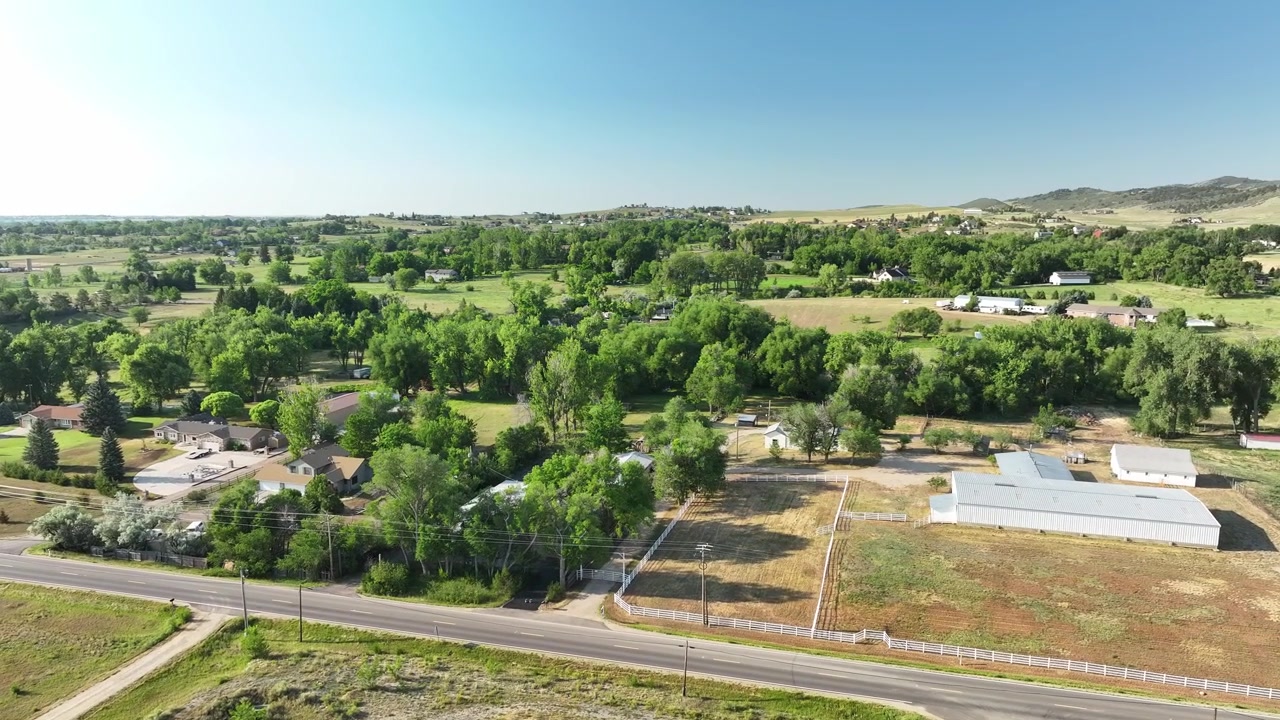Drone shot capturing the transitional zone between suburban acreage and rugged mountain topography in Loveland, CO.