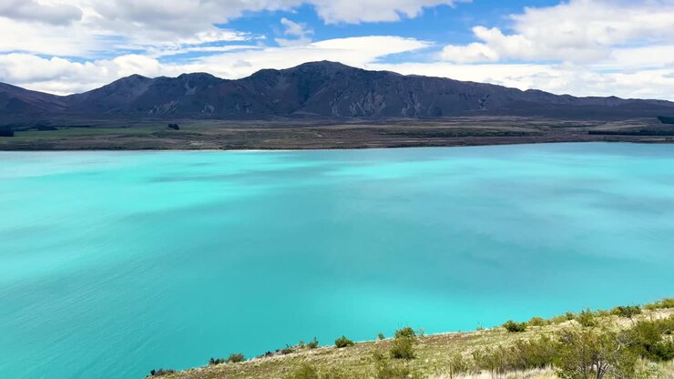 Vista serena del lago Tekapo con montagne, atmosfera tranquilla, ripresa alla luce del giorno
