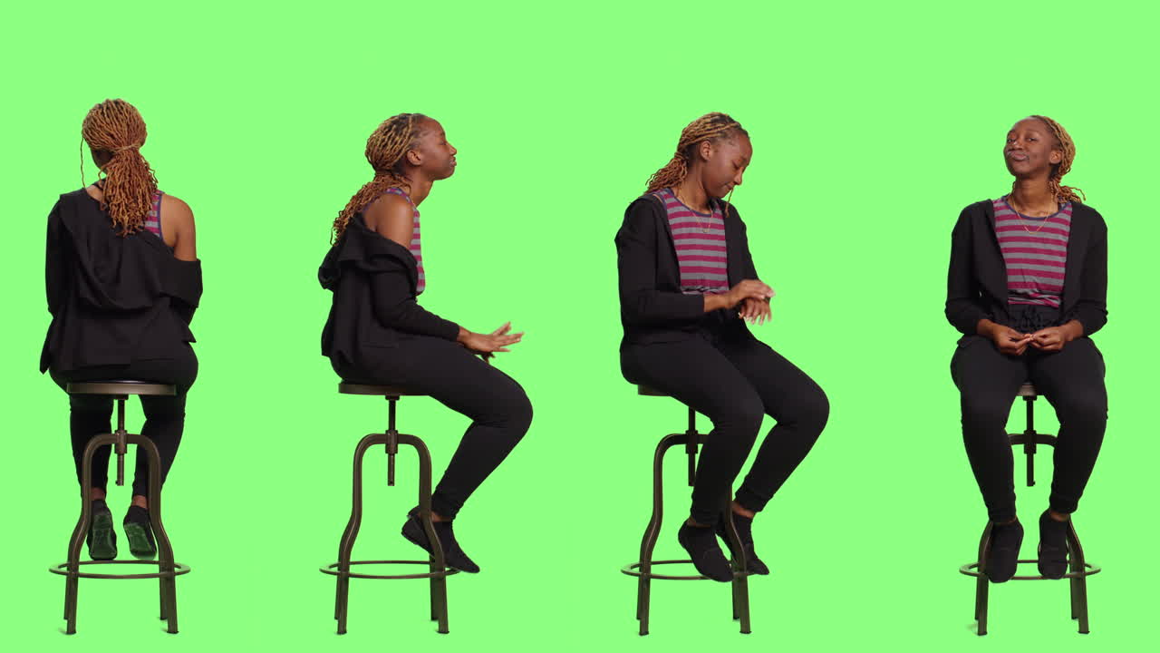 Woman sitting on stool in front of green screen