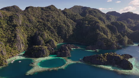 aerial drone view of coron island’s dramatic cliffs, tropical greenery, and idyllic turquoise waters, philippines.