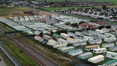 static caravan trailer beachfront staycation holiday home campground resort aerial descending view above railway tracks