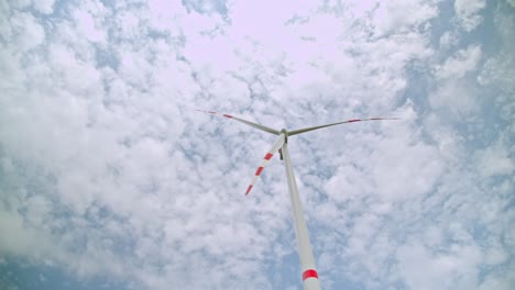 wind turbine spinning with clouds in the sky in the background