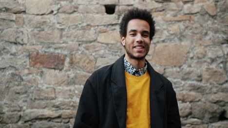 stylish man in front of stone wall