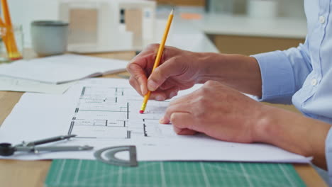 primer plano de arquitecto masculino en la oficina en el escritorio trabajando en planes para un nuevo edificio