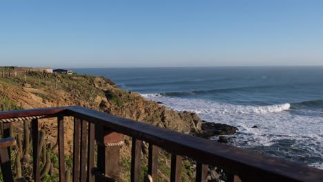 man watching the ocean waves from a cliff