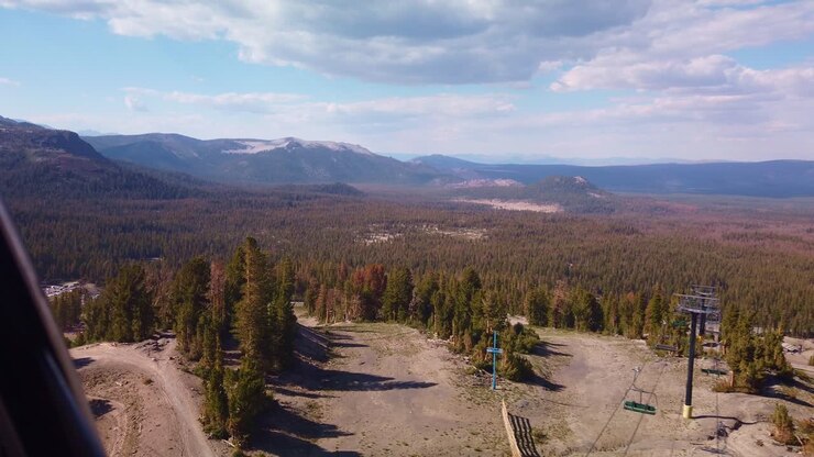 Inquadratura statica con gimbal da una gondola che passa sopra gli impianti di risalita sul Mammoth Mountain in California durante l'estate.