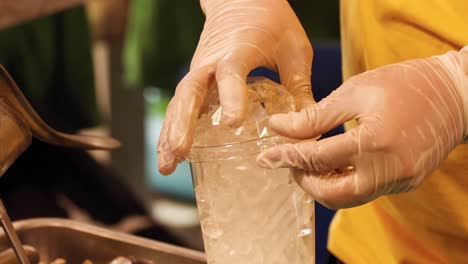 hands carefully place a lid on a cup filled with ice, showcasing attention to detail and hygiene.
