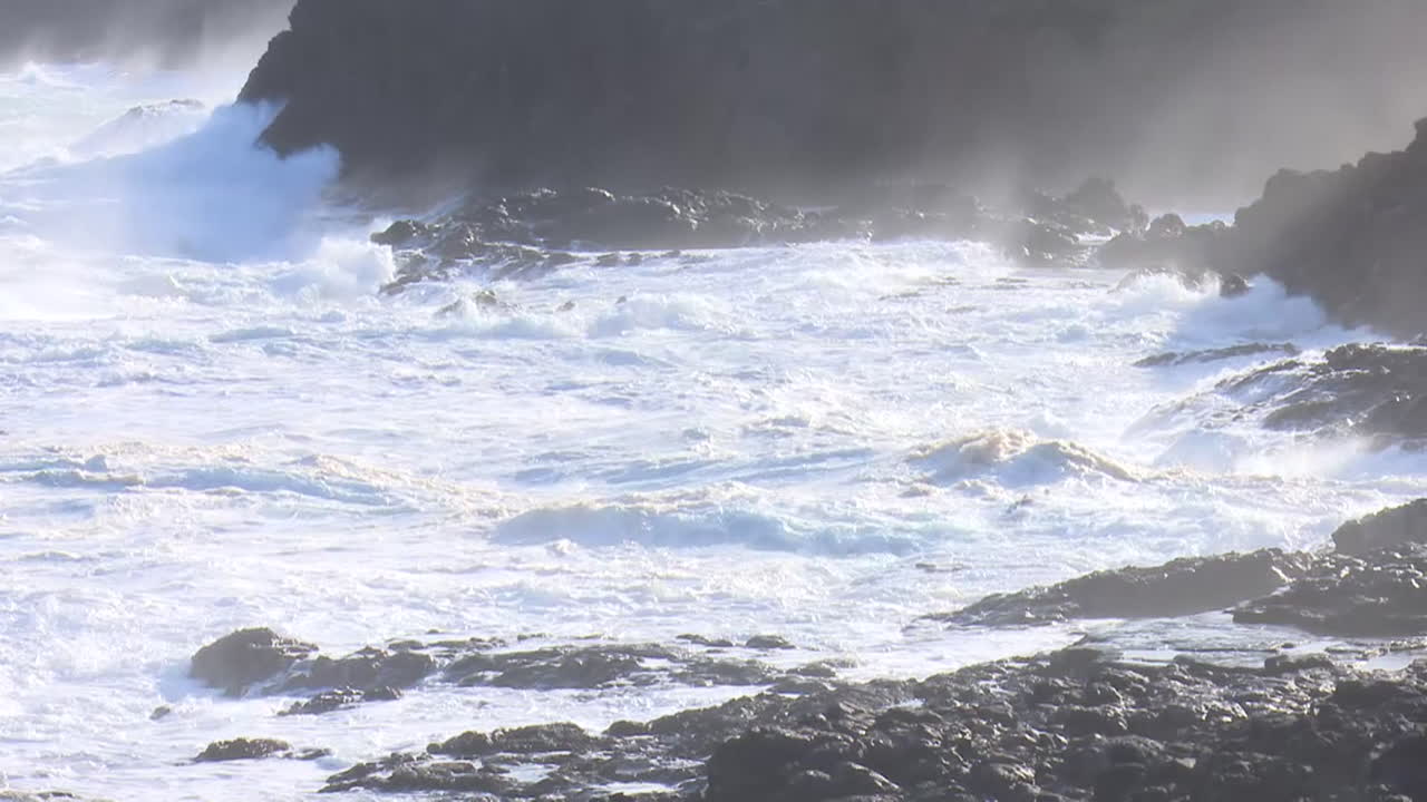 강력한 파도가 바위가 있는 해안에 부히고