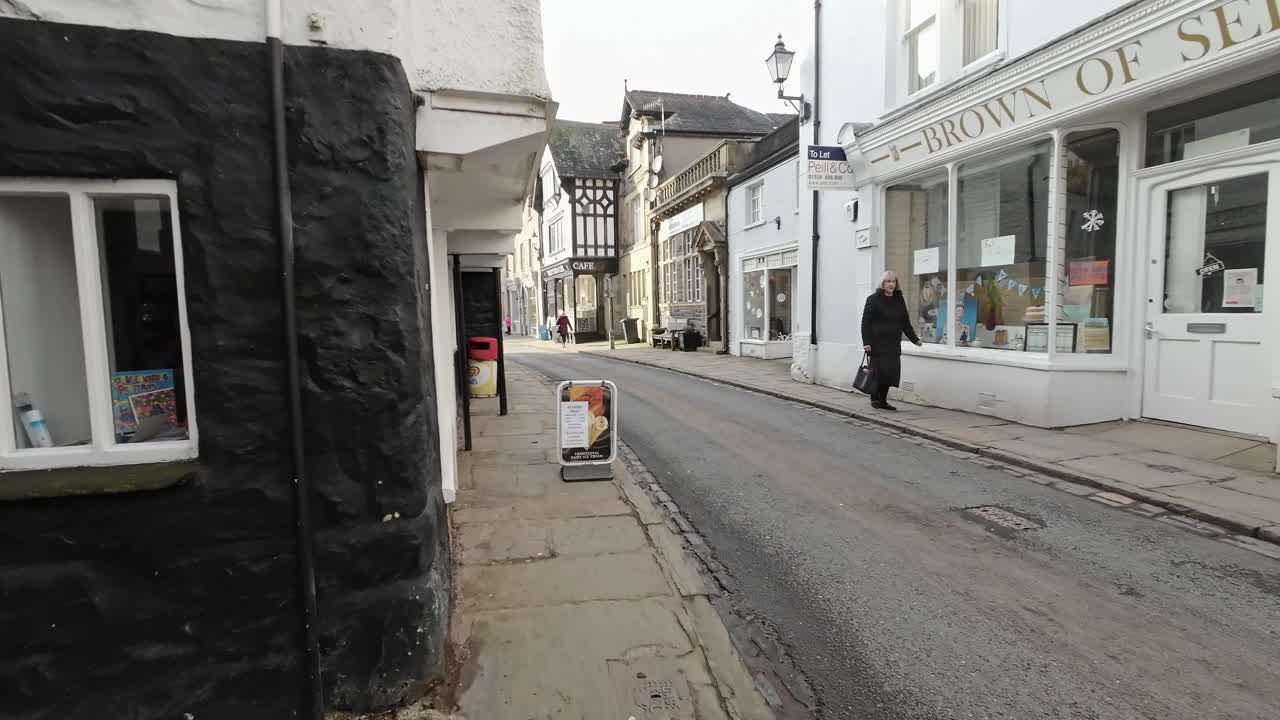 Editorial footage of the Cumbrian Village of Sedbergh in the English Lake District. Showing traffic and tourists walking and shopping