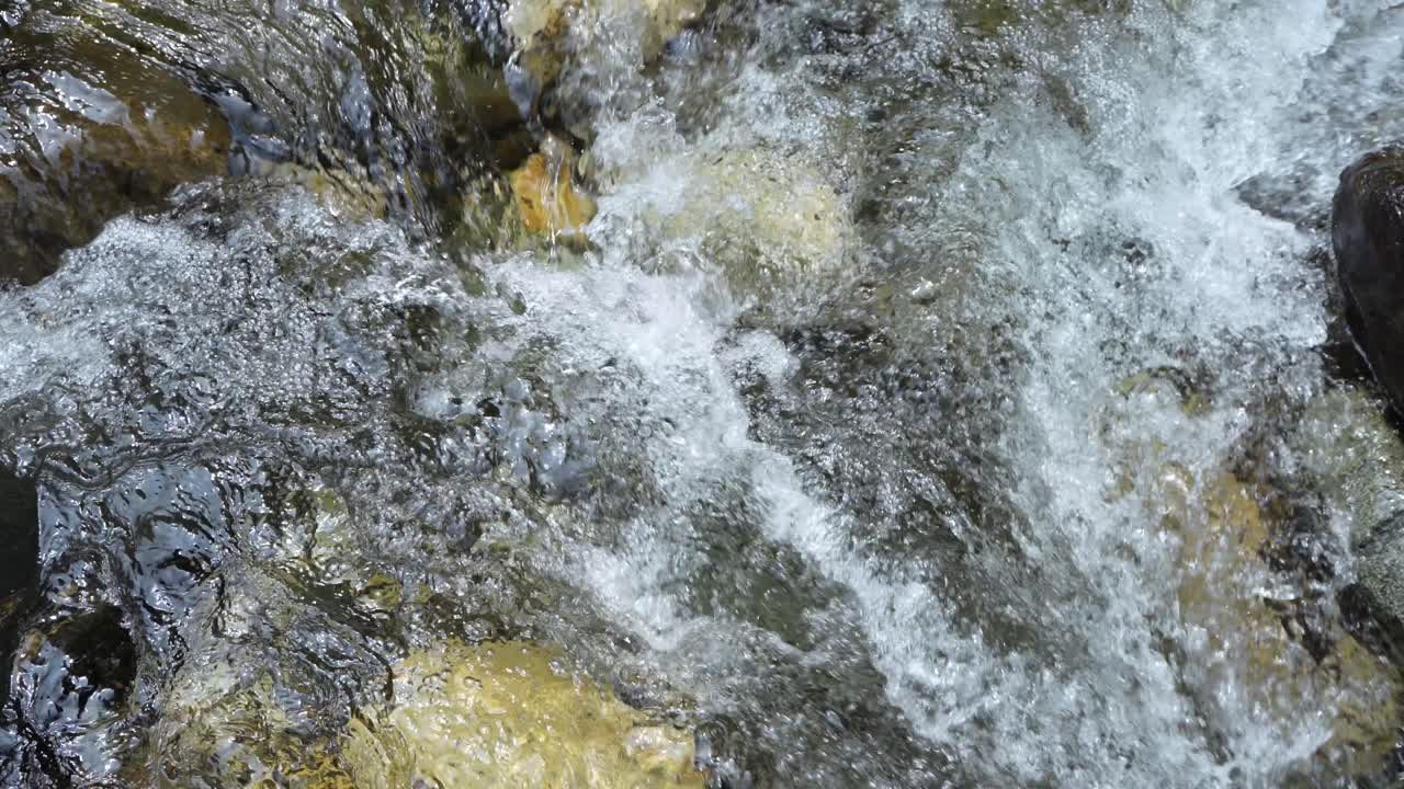 L'acqua scorre attraverso un fiume montano torrenziale