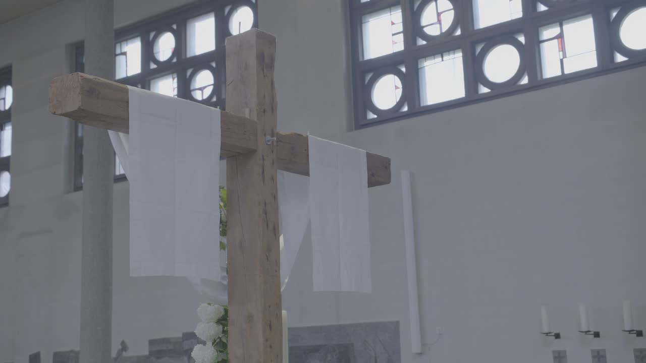 A white cloth hangs over a wooden cross in a church