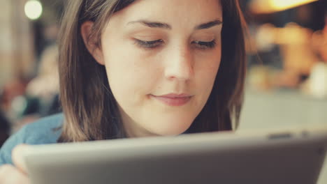 mujer usando una pantalla táctil de una tableta en un café