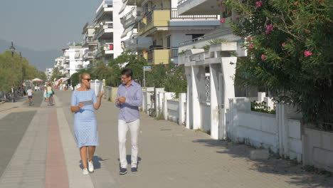 Young-woman-and-man-going-dancing-and-using-tablet-on-the-street-Thessaloniki-Greece