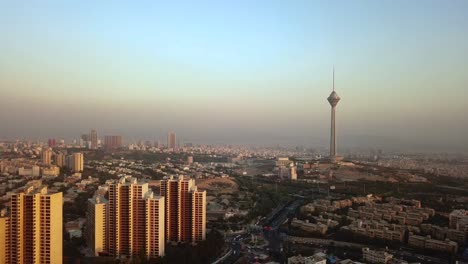 Milad-Tower-Teheran-Iran-Und-Blockgebäude-Im-Sonnenuntergang-Landschaft-Des-Blauen-Himmels-über-Luftverschmutzung-Stadtlebenskonzept-Und-Luftverschmutzung-In-Der-Großstadtarchitektur-Beherbergt-Autos,-Die-Auf-Der-Autobahn-Fahren