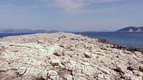 Vista-Aérea-Delantera-De-La-Apartada-Playa-Pedregosa-De-Paralia-Emplisi,-Grecia