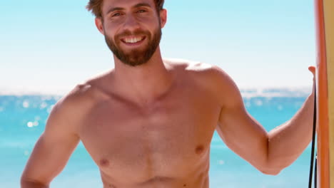 hombre guapo de pie con una tabla de surf