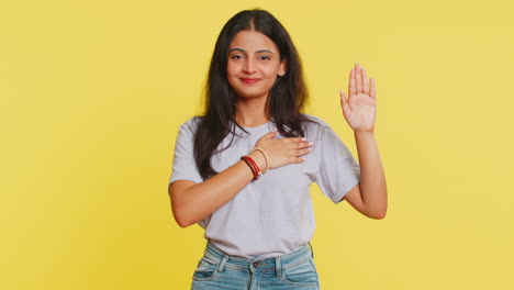 Indian-woman-raising-hand-to-take-oath-promising-to-be-honest,-to-tell-truth-keeping-hand-on-chest