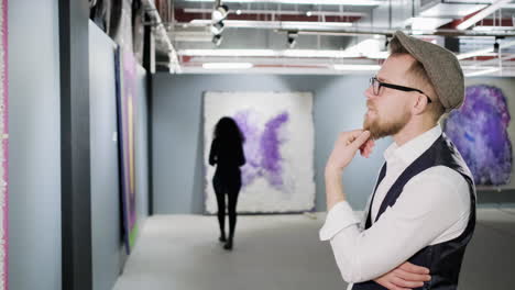 man and woman viewing abstract art in gallery