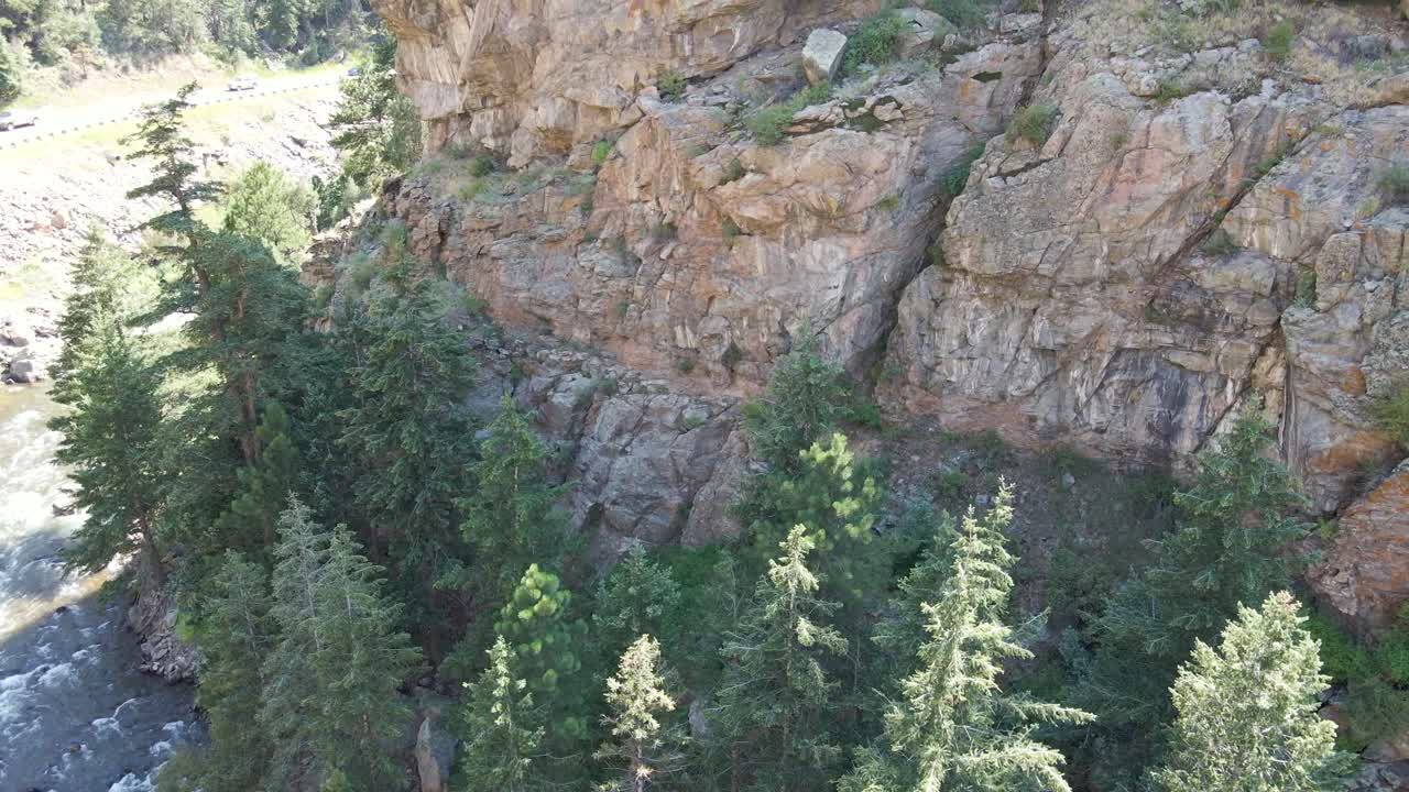 Cliff Overlooking Stream and Scenic Road in Colorado (USA) | Aerial View Panning Up | Summer 2021