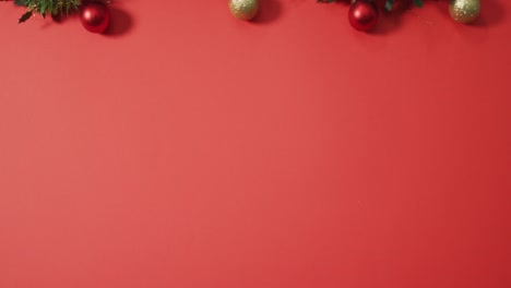 Christmas-decorations-with-baubles-and-copy-space-on-red-background