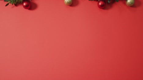 christmas decorations with baubles and copy space on red background