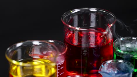 beakers with colorful liquids and smoke reaction