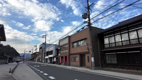 deserted street with shops and houses under a cloudy sky near amanohashidate station, kyoto, japan