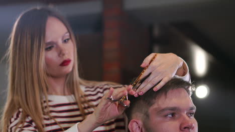 Close-up,-master-hairdresser-does-hairstyle-and-style-with-scissors-and-comb.-Concept-Barbershop.