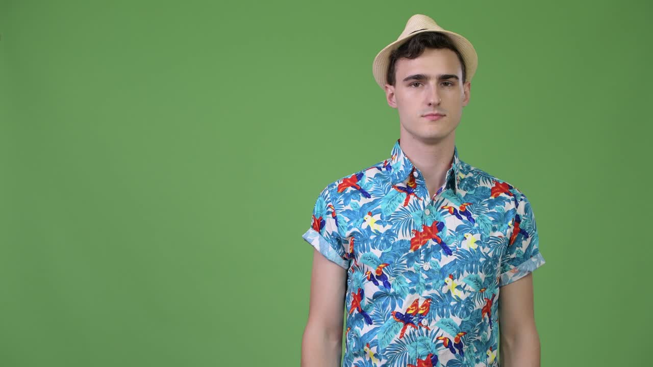 Young handsome tourist man showing something