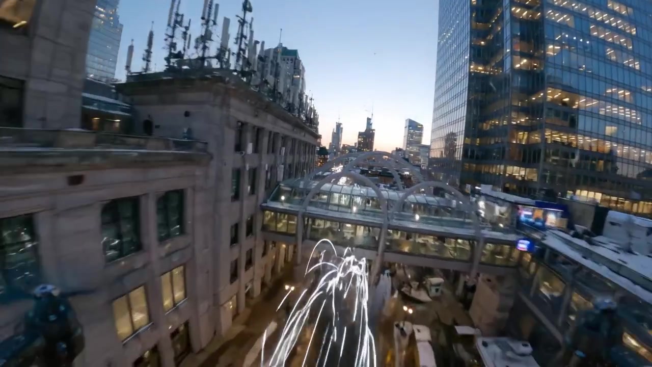 Aerial View of Urban Cityscape at Dusk with Vibrant Light Trails and Snow-Covered Rooftops, Capturing the Essence of Winter Landscape in a Bustling Metropolis