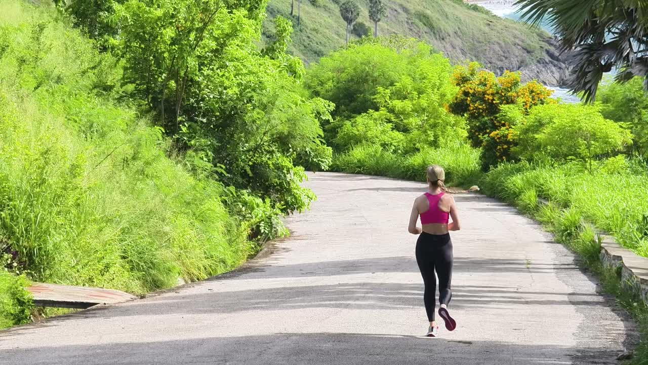 mujer corriendo por un camino tropical