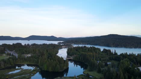 Backwards-moving-aerial-shot-over-forests-and-Sooke-river-on-Vancouver-Island