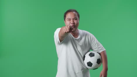 man excitedly pointing at viewer with soccer ball