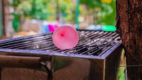 cinemagrafa de humo emitido por una parrilla de barbacoa caliente con un globo de agua colocado sobre ella.