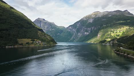 flying over a big fjord or lake in a green valley in a mountain range, norway, europe, drone