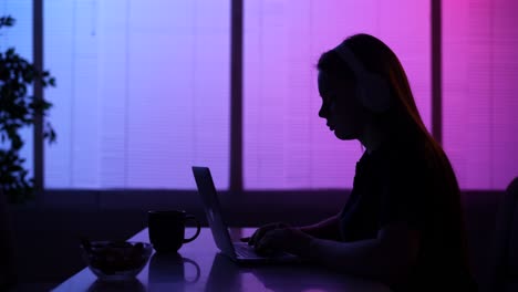 mujer trabajando en la computadora portátil por la noche