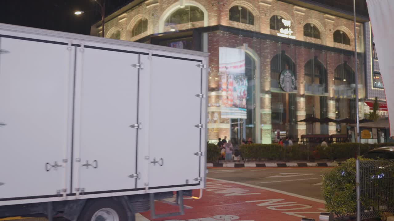 View of vehicles passing by the roads of Kuala Lumpur during night with Starbucks at background in Malaysia.