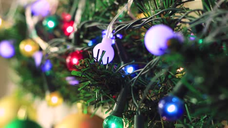 las luces de la guirnalda de navidad multicolor en la rama verde parpadean.