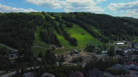 ski resort summer day with aerial gondola lift on green hill slope