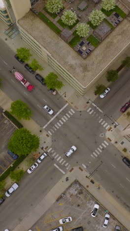 cars crossing the crossroads in the chicago downtown. view of the city roofs and parking lots from top at day time. vertical video