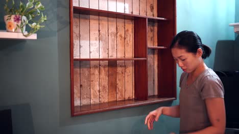 ethnic woman renovating wooden shelves at home