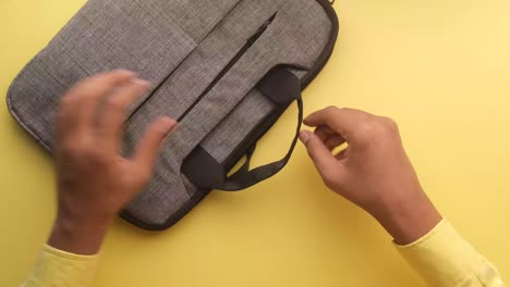 hands opening a gray laptop bag