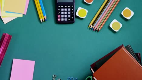 school supplies arranged on green background