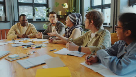 cheerful diverse students chatting in classroom during language lesson