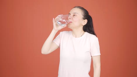 the woman is drinking water.