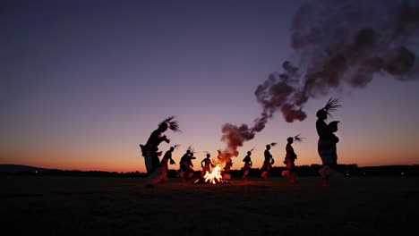 tribal dance around a campfire at sunset