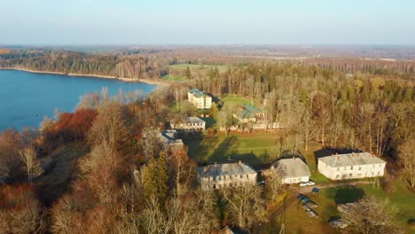 Old-Red-Brick-House,-Katvari-Manor-in-Latvia-and-Katvaru-Lake-in-the-Background