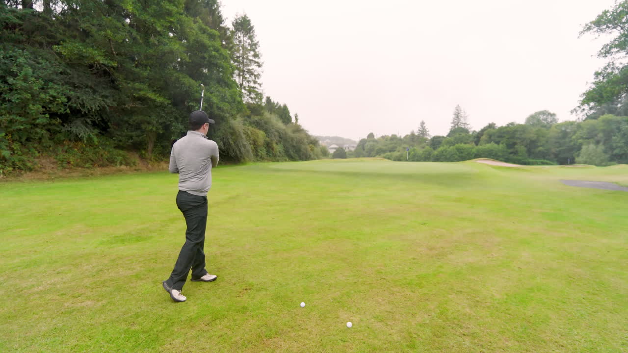 Male golf player playing golf, hitting the ball with club on a golf course, copy space